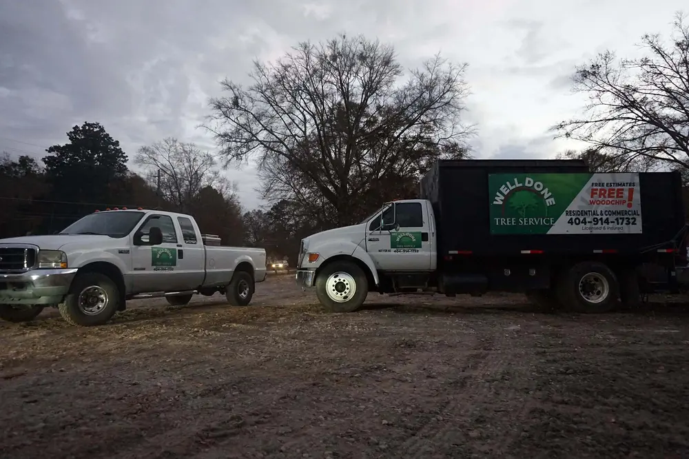 Two Well Done Tree Service trucks staged side by side before heading out to a job
