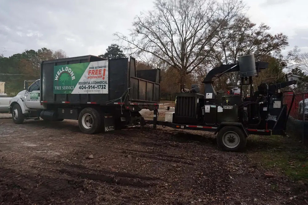 Well Done Tree Service dump truck and towed chipper staged at the start of a job